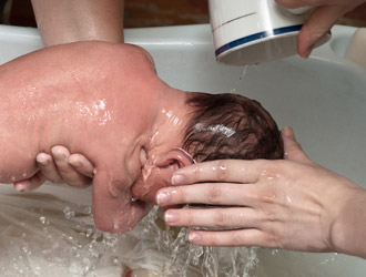 Pouring water over baby's head